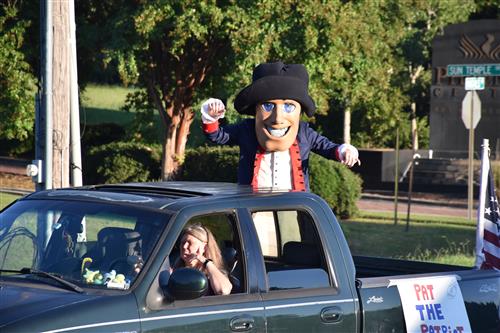 Pat the Patriot mascot from back of truck bed in parade